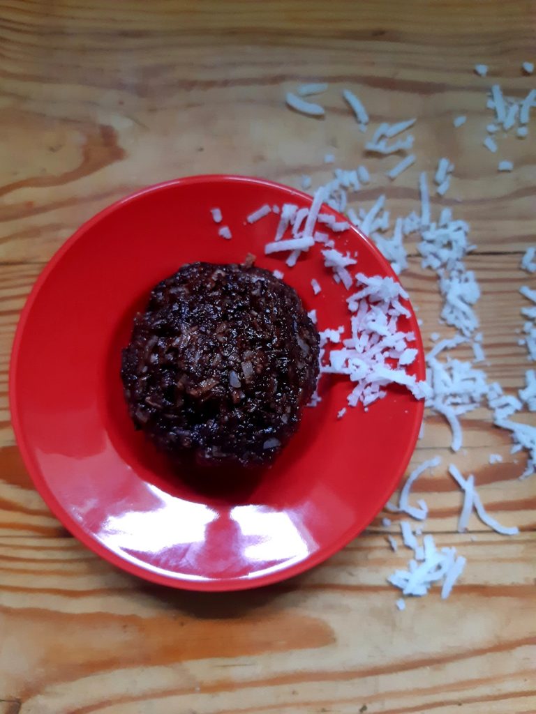 Photo d'une boule d'énergie chocolat et noix de coco végane et crue